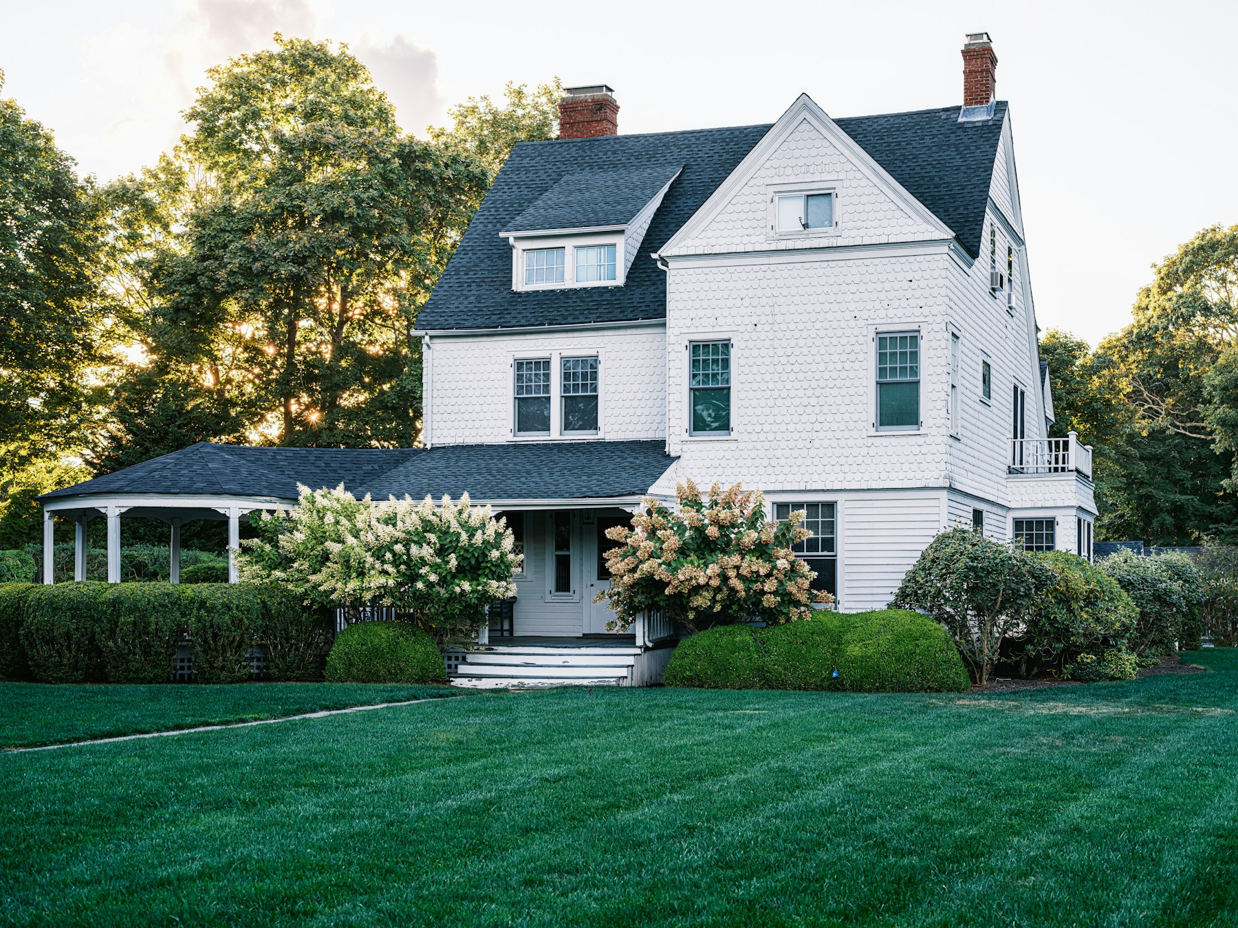 Shingle-style home with a landscaped lawn